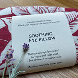 Irish Linen soothing eye pillow with red floral print and lavender scent on a wooden surface