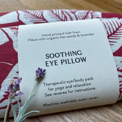 Irish Linen soothing eye pillow with red floral print and lavender scent on a wooden surface