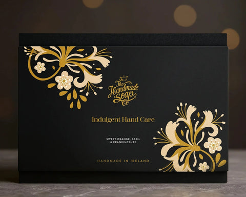 The Handmade Soap Company Indulgent Hand Care Gift Set. A black box with gold and white floral designs and 'The Handmade Soap' branding.
